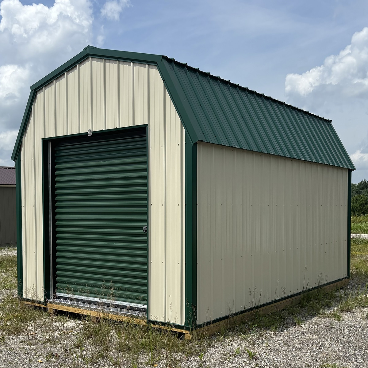 Taupe metal-sided lofted barn with green garage door, green roof, and green trim.